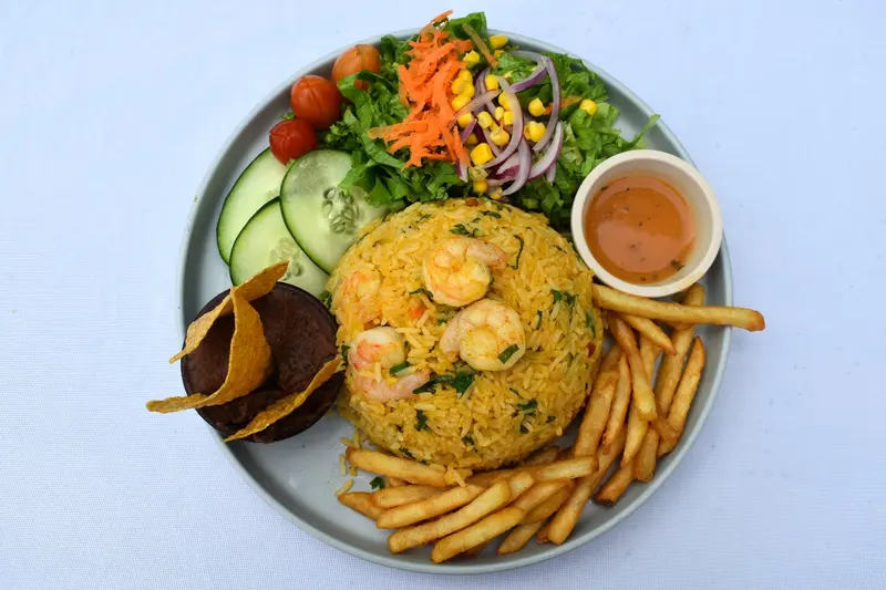 Arroz con camarones con papas fritas, ensalada y patacón