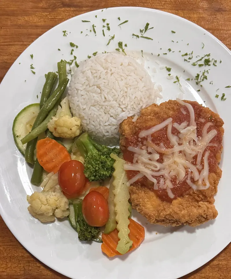 Pollo parmesano empanizado con salsa roja y queso, arroz y vegetales